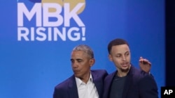 Former President Barack Obama, left, hugs Golden State Warriors basketball player Stephen Curry after speaking at the My Brother's Keeper Alliance Summit in Oakland, Calif., Feb. 19, 2019.