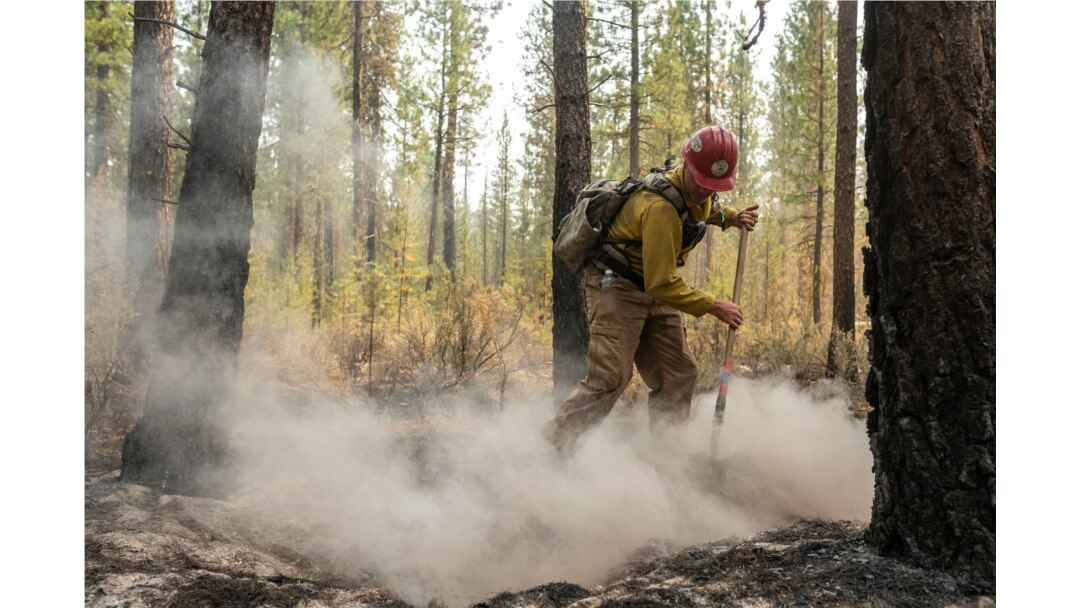 El bombero Garrett Suza, del Servicio Forestal de Chiloquin, limpia un punto caliente en el lado noreste del incendio Bootleg, el miércoles 14 de julio de 2021, cerca del río Sprague, Oregon (AP Photo / Nathan Howard)