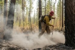 El bombero Garrett Suza, del Servicio Forestal de Chiloquin, limpia un punto caliente en el lado noreste del incendio Bootleg, el miércoles 14 de julio de 2021, cerca del río Sprague, Oregon (AP Photo / Nathan Howard)