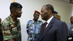 Ivory Coast's President Alassane Ouattara (R) shakes hands with General Philippe Mangou, chief of staff of former pro-Laurent Gbagbo Defense and Security Forces (FDS), at the Hotel du Golf in Abidjan, April 12, 2011 (file photo)
