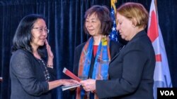 Sandy Sugawara is sworn in by VOA Director Amanda Bennett as VOA's new Deputy Director. Kelu Chao, Associate Director for Language Programming, holds the U.S. Constitution.