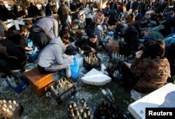 Warga setempat menyiapkan bom molotov untuk mempertahankan kota, setelah Rusia melancarkan operasi militer besar-besaran terhadap Ukraina, di Uzhhorod, Ukraina, 27 Februari 2022. (Foto: REUTERS/Serhii Hudak)