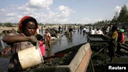 Penduduk desa berkumpul di sungai untuk mengolah lumpur yang mengandung emas, akibat bocornya pipa milik penambangan tembaga dan emas AS, Freeport McMoRan, di desa Kwanki Lama, provinsi Papua, 8 Oktober 2011. (Foto: dok).
