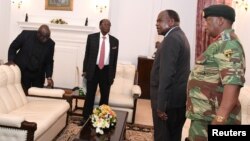 FILE - Zimbabwe's President Robert Mugabe meets with Father Fidelis Mukonori, Secretary to the Cabinet Dr Misheck Sibanda and Defense Forces Commander General Constantino Chiwenga at State House in Harare, Nov. 19, 2017. 