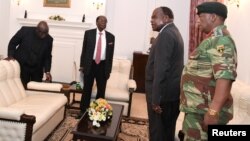 FILE - Zimbabwe's President Robert Mugabe meets with Father Fidelis Mukonori, Secretary to the Cabinet Dr Misheck Sibanda and Defense Forces Commander General Constantino Chiwenga at State House in Harare, Nov. 19, 2017. 