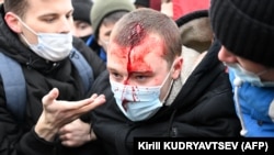 Un homme blessé est aidé par d'autres manifestants dans le centre de Moscou le 23 janvier 2021.