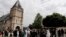Muslim worshipers gather in front of the memorial at the Saint Etienne church, in Saint-Etienne-du-Rouvray, Normandy, France, July 29, 2016. 