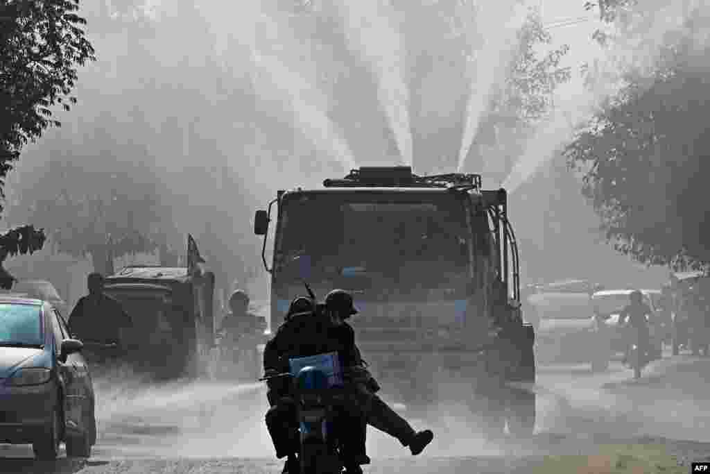 A vehicle of the Water and Sanitation Agency (WASA) sprays water using an anti-smog gun to curb air pollution amid heavy smoggy conditions in Lahore, Pakistan. (Photo by Arif ALI / AFP)