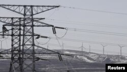 Power lines and wind turbines are seen at a wind and solar energy storage and transmission power station of State Grid Corporation of China, in Zhangjiakou of Hebei province, China, March 18, 2016. 
