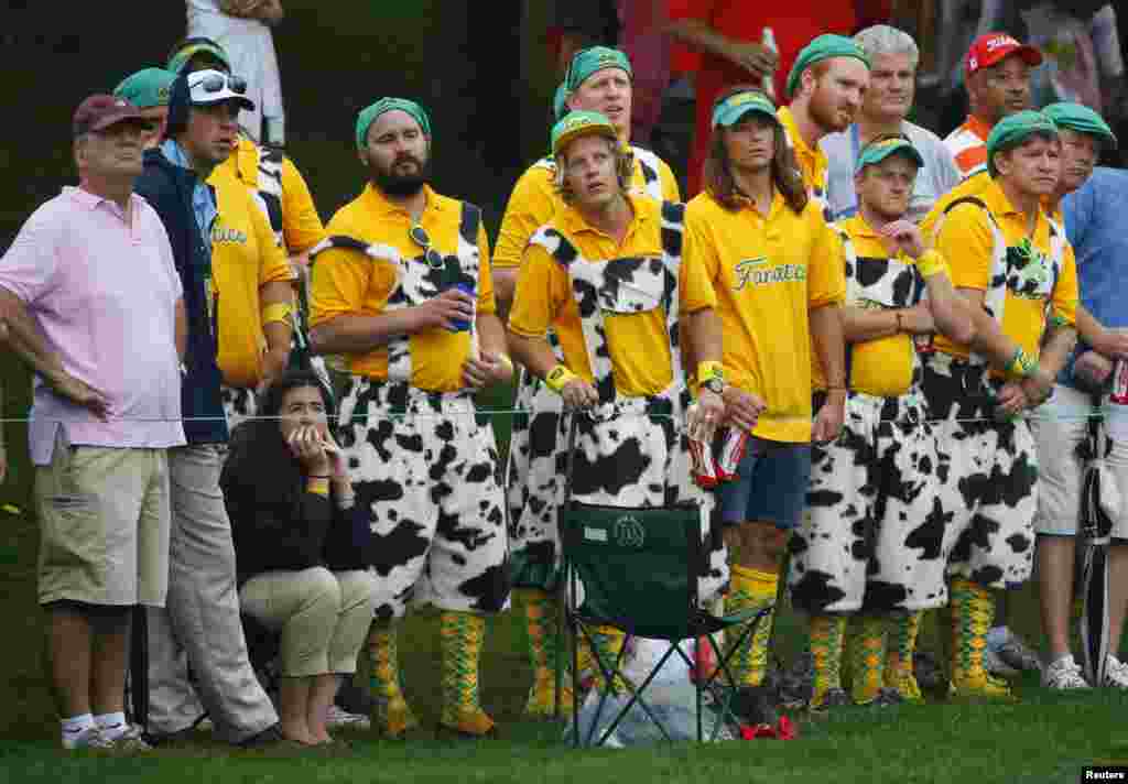 Fans watch as Tiger Woods of the U.S. and playing partner Matt Kuchar face International team members Adam Scott of Australia and Hideki Matsuyama of Japan in their four ball match at the 2013 Presidents Cup golf tournament at Muirfield Village Golf Club in Dublin, Ohio, USA.