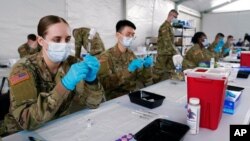 ARCHIVO - Especialistas en salud del Ejército llenan jeringas con la vacuna Pfizer COVID-19 en Miami, Florida, el 9 de marzo de 2021.