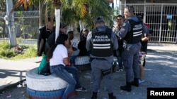 Oficiales de la policía migratoria de Costa Rica hablan con migrantes venezolanos en la frontera con Panamá tras las nuevas políticas migratorias del presidente de EEUU, Donald Trump, en Paso Canoas, Costa Rica, el 12 de febrero de 2025. REUTERS/Maynor Valenzuela.