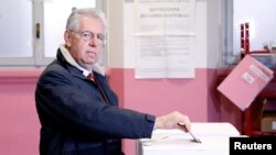 Perdana Menteri Italia Mario Monti tengah memasukkan surat suaranya ke kotak suara di salah satu TPS di Milan, 24 February 24 2013. 