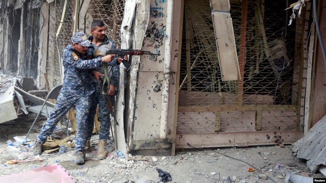 A member of the Iraqi Federal Police opens fire against Islamic State militants in the Old City of Mosul, Iraq July 7, 2017. 