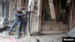 A member of the Iraqi Federal Police opens fire against Islamic State militants in the Old City of Mosul, Iraq July 7, 2017. 