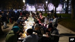 La gente come comidas proporcionadas por la organización Red Solidaria en la Plaza de Mayo, frente a la casa de gobierno, en Buenos Aires, Argentina, el 6 de junio de 2024.