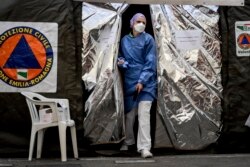A paramedic wearing a mask gets out of a tent set up by the Italian Civil Protection outside the emergency ward of the Piacenza hospital, northern Italy, Feb. 27, 2020.