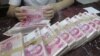 An employee counts Chinese 100 yuan banknotes at a branch of Bank of Communications in Shenyang, Liaoning province July 6, 2012.