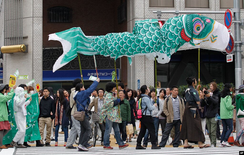 Participants carry a large traditional carp-shaped wind sock called "Koinobori" at a parade demanding a stop to all nuclear power plants in Japan as part of an event for Earth Day in Tokyo April 22, 2012. Japan is set to have no nuclear power within weeks