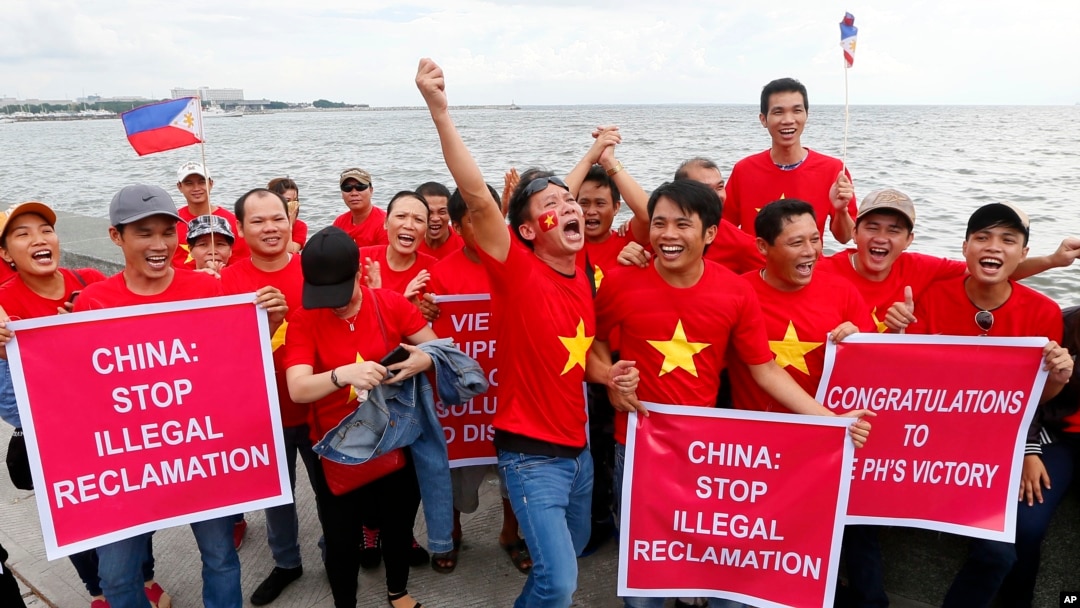 Kaum ekspatriat Vietnam bersorak sambil mengacungkan plakat selama terjadinya unjuk rasa di tepi jalur pejalan kaki sebelum pengadilan arbitrase internasional PBB yang berpusat di Den Hague mengumumkan keputusannya terkait dengan sengketa di Laut China Selatan, Selasa (12/7). 