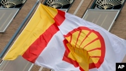 Bendera berlogo perusahaan Royal Dutch Shell, sebuah perusahaan minyak dan gas Inggris-Belanda, berkibar di luar kantor pusat di Den Haag, Belanda. (Foto: AP)