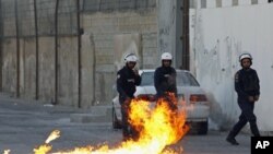 Riot police step back as a Molotov cocktail fired by anti-government protesters explodes during clashes in the village of Sanabis, west of Manama, Bahrain, February 12, 2012.