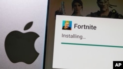 Fortnite game installing on Android operating system is seen in front of Apple logo in this illustration taken, May 2, 2021. (REUTERS/Dado Ruvic/Illustration)