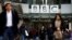 FILE - Pedestrians walk past a BBC logo at Broadcasting House in London, Britain, Jan. 29, 2020. 