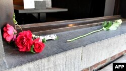Flowers are layed at the cafe Les Augustins, just after the security perimetre was lifted, at the scene of a deadly shooting on the boulevard d'Avroy in the eastern Belgian city of Liege, on May 29, 2018.
