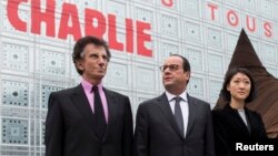 El presidente francés, François Hollande (centro) y la ministra de Cultura, Fleur Pellerin (derecha) y el presidente del Institut du Monde Arabe, Jack Lang (L) posan frente a un rótulo que lee "Yo soy Charlie".