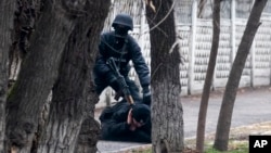  An armed riot police officer detains a protester after clashes in Almaty, Kazakhstan, Jan. 8, 2022. 