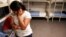 FILE - An unidentified Guatemalan woman and a child are seen inside a dormitory in the Artesia Family Residential Center, a federal detention facility for undocumented immigrant mothers and children in Artesia, New Mexico, Sept. 10, 2014.