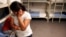 FILE - An unidentified Guatemalan woman and a child are seen inside a dormitory in the Artesia Family Residential Center, a federal detention facility for undocumented immigrant mothers and children in Artesia, New Mexico, Sept. 10, 2014.