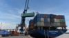 FILE - Containers are transferred from a truck to a cargo ship at the international cargo terminal of a port in Hai Phong, Vietnam, Aug. 12, 2019.