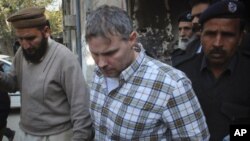 ທ່ານ Raymond Davis ນັກການທູດສະຫະລັດ ກໍາລັງຖືກເຈົ້າໜ້າທີ່
ຕໍາຫລວດປາກິສຖານ ນໍາໂຕອອກຈາກສານທີ່ເມືອງ Lahore.