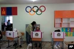 Mongolians prepare their votes at a polling station in Ulaanbaatar on June 28, 2024.