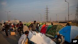 Volunteers put up tents for protesting farmers in the middle of a major highway which is blocked in a protest against new farm laws at the Delhi-Uttar Pradesh state border, India, Dec. 25, 2020.