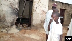 A child covers his nose inside a mosque where a suicide bomber killed over 20 worshippers in Maiduguri, Sept. 21, 2015. 