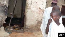 A child covers his nose inside a mosque where a suicide bomber killed over 20 worshipers in Maiduguri, Sept. 21, 2015.