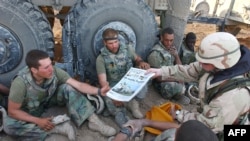 FILE - Copies of Stars and Stripes newspaper are delivered to U.S. Marines in this image released by the U.S. Navy, April 7, 2003.