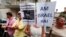 A woman holds signs reading, 'The Jewish People Live' (R) and 'He can celebrate his birthday, his victims no' during a protest against convicted former Nazi SS captain Erich Priebke in Rome, July 29, 2013.