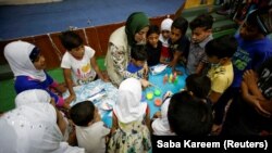 Ibu tunggal Irak Marwa Raed Taha, yang bekerja sebagai sukarelawan, mengajar anak-anak, di penampungan Amiriya di Baghdad, Irak, 21 April 2021. (Foto: REUTERS/Saba Kareem)