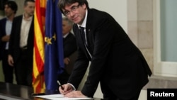 Catalan President Carles Puigdemont signs a declaration of independence at the Catalan regional parliament in Barcelona, Spain, Oct. 10, 2017.