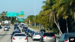Antrean mobil mengular setelah menyeberangi perlintasan ke Miami Beach, Florida, menjelang libur panjang Hari Pahlawan, 28 Mei 2021. (Foto: AP)