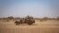 In this file photo taken on Feb. 03, 2020, Burkina Faso soldiers patrol aboard a pick-up truck on the road from Dori to the Goudebo refugee camp.