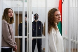 FILE - Journalists Katsiaryna Andreyeva, right, and Daria Chultsova stand inside a defendants' cage in a court room in Minsk, Belarus, Feb. 18, 2021. …