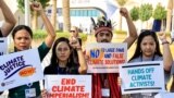 Activists hold placards and shout slogans during a protest at the United Nations climate summit COP28 in Dubai, United Arab Emirates, on Dec. 6, 2023.