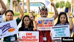 Activists hold placards during a protest, at the COP28 United Nations Climate Conference in Dubai, United Arab Emirates, Dec. 6, 2023.