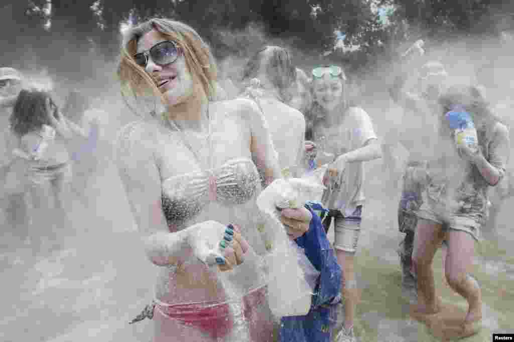 Youths throw flour at each other during the &quot;Battle with Flour&quot; on the banks of the Dnipro River in Kyiv, Ukraine, June 22, 2013.