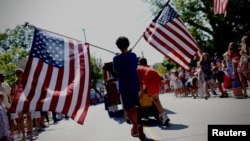 Фото: хлопчик з американськими прапорами в Массачусетсі, 4 липня 2024 року. Фото: REUTERS/Mike Segar